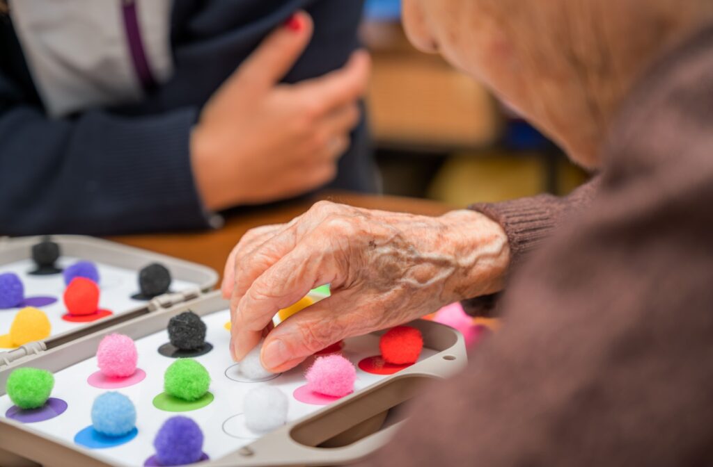 A close-up of a senior with dementia participating in an activity to stimulate brain and cognitive function in a memory care community.