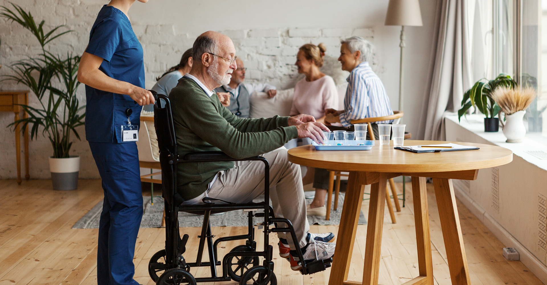 a senior man in wheelchair next to a table