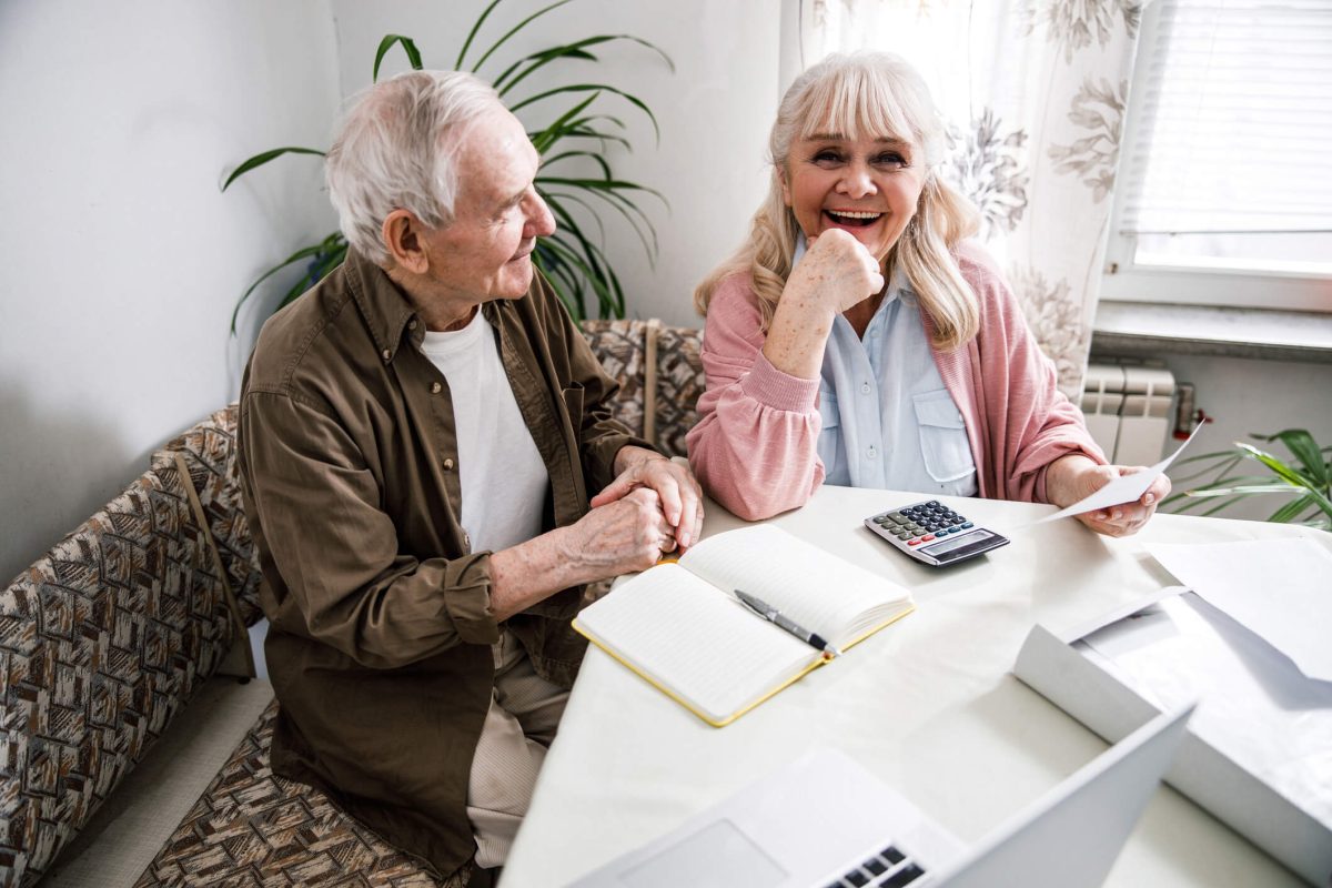 Money Matters: 5 Tips for Paying for a Move to a Senior Living Community Elder couple looking at finances at dinner table