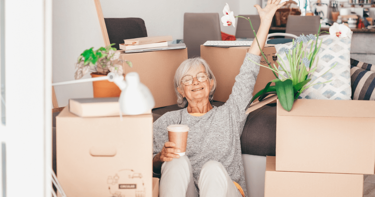 Older woman surrounded by boxes ready to move to senior living